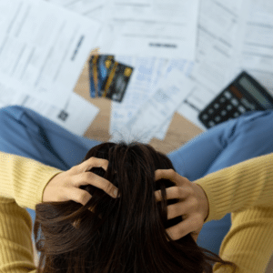 Person looking stressed with overdue bills symbolizing hidden costs of addiction